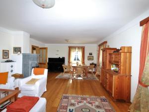 a living room with white furniture and a table at Almenblick in Kleblach