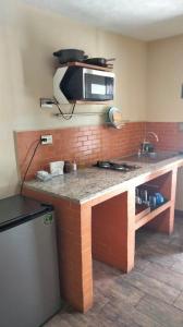 a kitchen with a counter with a microwave above it at Estancia Familiar cerca de Paseo Durango in Durango