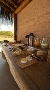 a wooden table with food on top of it at Pousada Nitxi Awêry in Caraíva