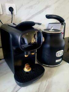 a black coffee maker and a tea kettle on a counter at Studio Paisible in Gien-sur-Cure