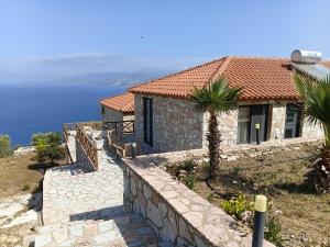 a house on a hill with a palm tree at Luxury Pigeons Cave Suites in Ksamil