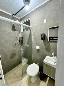 a bathroom with a shower and a toilet and a sink at Nônames Urban Hostel in Florianópolis +18 photos
