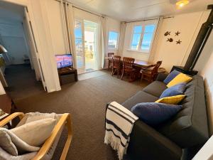 a living room with a couch and a dining room at Windy Garden in Marahau
