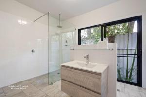 a white bathroom with a sink and a shower at Bessou in Charlotte Bay +15 photos