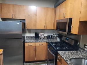 a kitchen with wooden cabinets and a stainless steel refrigerator at Just like home in Atlanta