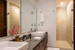 a bathroom with two sinks and a shower at DreamHaus Suites - Country Club Guadalajara in Guadalajara