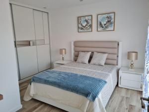 a bedroom with a bed with a blue blanket on it at appartement F2 in Ferrel