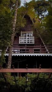 a wooden house with a window and a tree at Cabana Recanto da Araucária in Santa Cruz do Sul