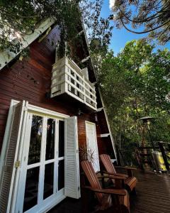 a porch of a house with two chairs and a balcony at Cabana Recanto da Araucária in Santa Cruz do Sul