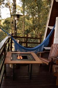 a hammock on a deck with a fire pit at Cabana Recanto da Araucária in Santa Cruz do Sul