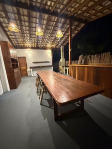 a large wooden table in a room with a piano at Chalé Átina - Atins in Atins +23 photos