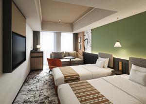 a hotel room with two beds and a television at Premium hotel MONday MAIHAMA VIEW 2 in Tokyo +12 photos