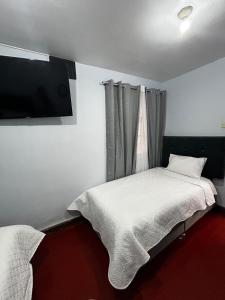 a bedroom with two beds and a flat screen tv at El Viejo Roble in Cusco