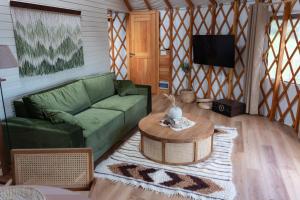 a living room with a green couch and a table at ETER Yurt Retreat in Stanišinci