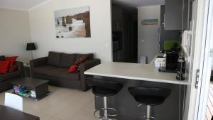 a kitchen and living room with a counter and a couch at Iconic Luxury & Ocean Views in Apollo Bay