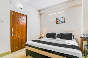 a bedroom with a bed and a wooden door at Super Hotel O Jessore Road Kolkata Formerly Skyline Serenity in Kolkata