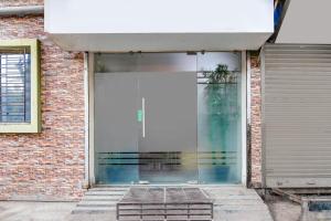 a glass entry door to a brick building at Super Hotel O Jessore Road Kolkata Formerly Skyline Serenity in Kolkata +31 photos