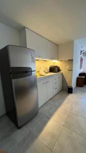 a kitchen with a stainless steel refrigerator and white cabinets at Mitre1349bis in Villa Basso