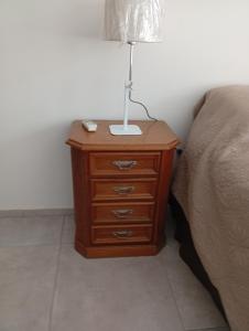 a nightstand with a lamp on it next to a bed at Mitre1349bis in Villa Basso