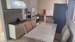 a small kitchen with a white table and chairs at Apartamento no Centro Proximo a Tudo in Barra do Garças