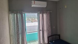 a bedroom with a window with curtains and a bed at Apartamento no Centro Proximo a Tudo in Barra do Garças