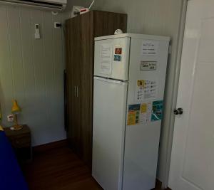 a white refrigerator in a room with a door at Bora Bora Vairupe lodge in Bora Bora