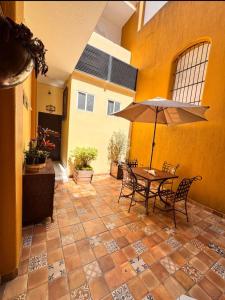 a patio with a table and chairs and an umbrella at Suites Central in Guadalajara