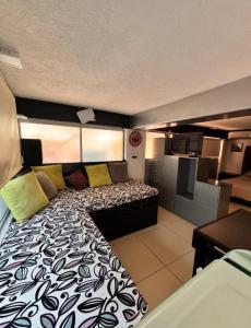 a bedroom with a large bed and a kitchen at Suites Central in Guadalajara