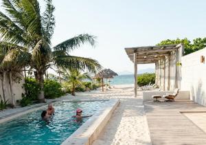 two people in a swimming pool next to the beach at Telchac 3 bedrooms, pool and beach in Telchac Puerto