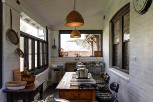 a kitchen with a table in a room with windows at Barbour House in Gunning