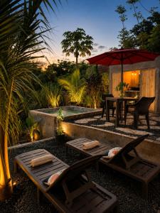a patio with chairs and a table and an umbrella at lux bungalows in Santa Catalina