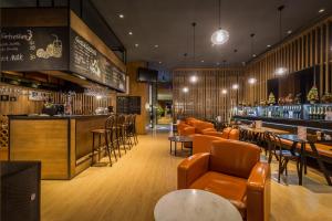 a restaurant with orange chairs and a bar at Beijing New World Centre Tongpai Hotel in Beijing