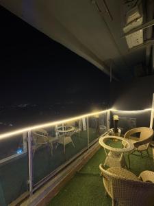 a balcony with tables and chairs at night at Moon Escape Studio in Ghaziabad