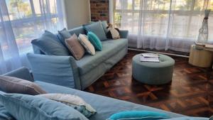 a living room with a blue couch with pillows at Cassana In The Cove in North Arms Cove