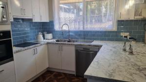 a kitchen with a sink and a dishwasher at Cassana In The Cove in North Arms Cove
