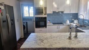 a kitchen with white cabinets and a marble counter top at Cassana In The Cove in North Arms Cove