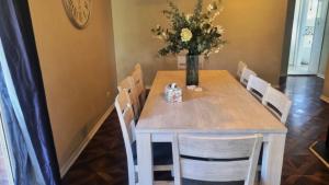 a dining room table with a vase of flowers on it at Cassana In The Cove in North Arms Cove
