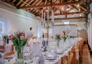 a long table with vases of flowers in a room at Bodensee-Schloss Maurach in Uhldingen-Mühlhofen