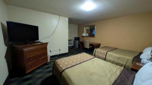 a hotel room with two beds and a flat screen tv at Slumberland Motel Mount Holly in Mount Holly
