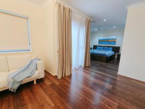 a living room with a couch and a bed at Modern Retreat by Underwood market&51 Area in Kuraby