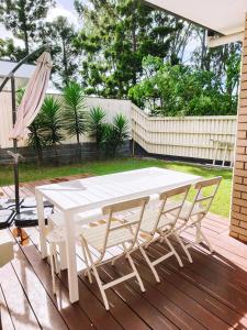 a white table and chairs on a wooden deck at Modern Retreat by Underwood market&51 Area in Kuraby