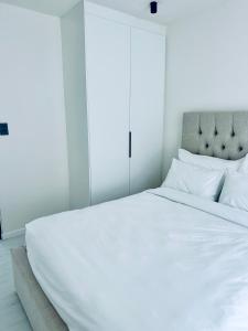 a large white bed with white sheets and pillows at Casa RuMat in Swakopmund