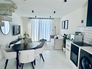 a kitchen and living room with a table and chairs at Casa RuMat in Swakopmund