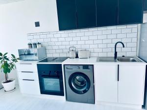 a kitchen with a washing machine and a sink at Casa RuMat in Swakopmund