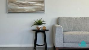a table with a plant on it next to a chair at Beachside Oasis in Caves Beach