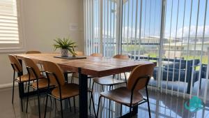 a wooden table with chairs and a potted plant on it at Beachside Oasis in Caves Beach
