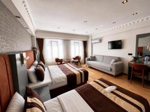 ein Hotelzimmer mit zwei Betten und einer Couch in der Unterkunft The PeraPort Hotel in Istanbul