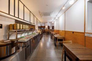 a restaurant with a row of counters and tables at Kenny Stay Busan Gijang in Busan