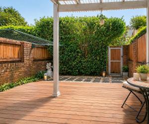 a wooden deck with a pergola in a backyard at Relaxing 2BR Split-Level Home in Wahroonga in Waitara