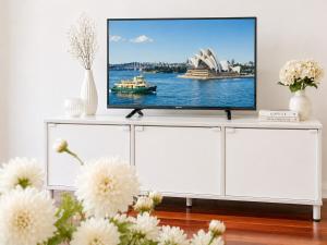 a living room with a tv on a white cabinet at Relaxing 2BR Split-Level Home in Wahroonga in Waitara